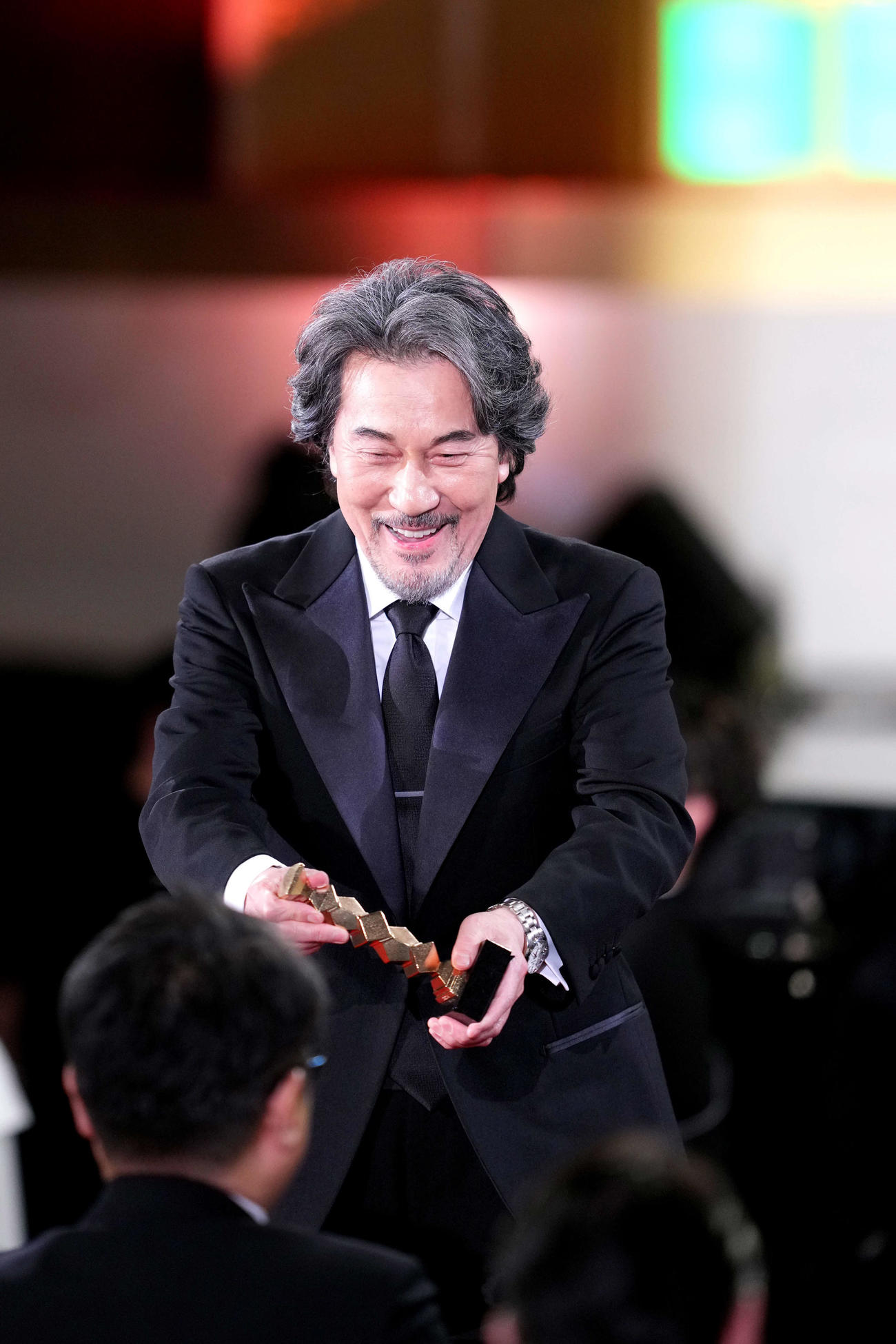 最優秀監督賞授賞式でヴィム・ヴェンダース監督の代理を務めた役所広司は笑顔で席に戻る（撮影・横山健太）