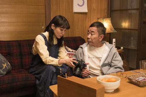 遺影とは思えないポーズをとる雅彦に呆れながら撮影する瞳／「春になったら」第９話あらすじ