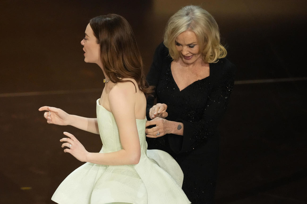 第96回アカデミー賞授賞式で、主演女優賞を受賞したエマ・ストーン（左）はドレスのファスナーが壊れてしまいジェシカ・ラングに直してもらおうとする（AP）