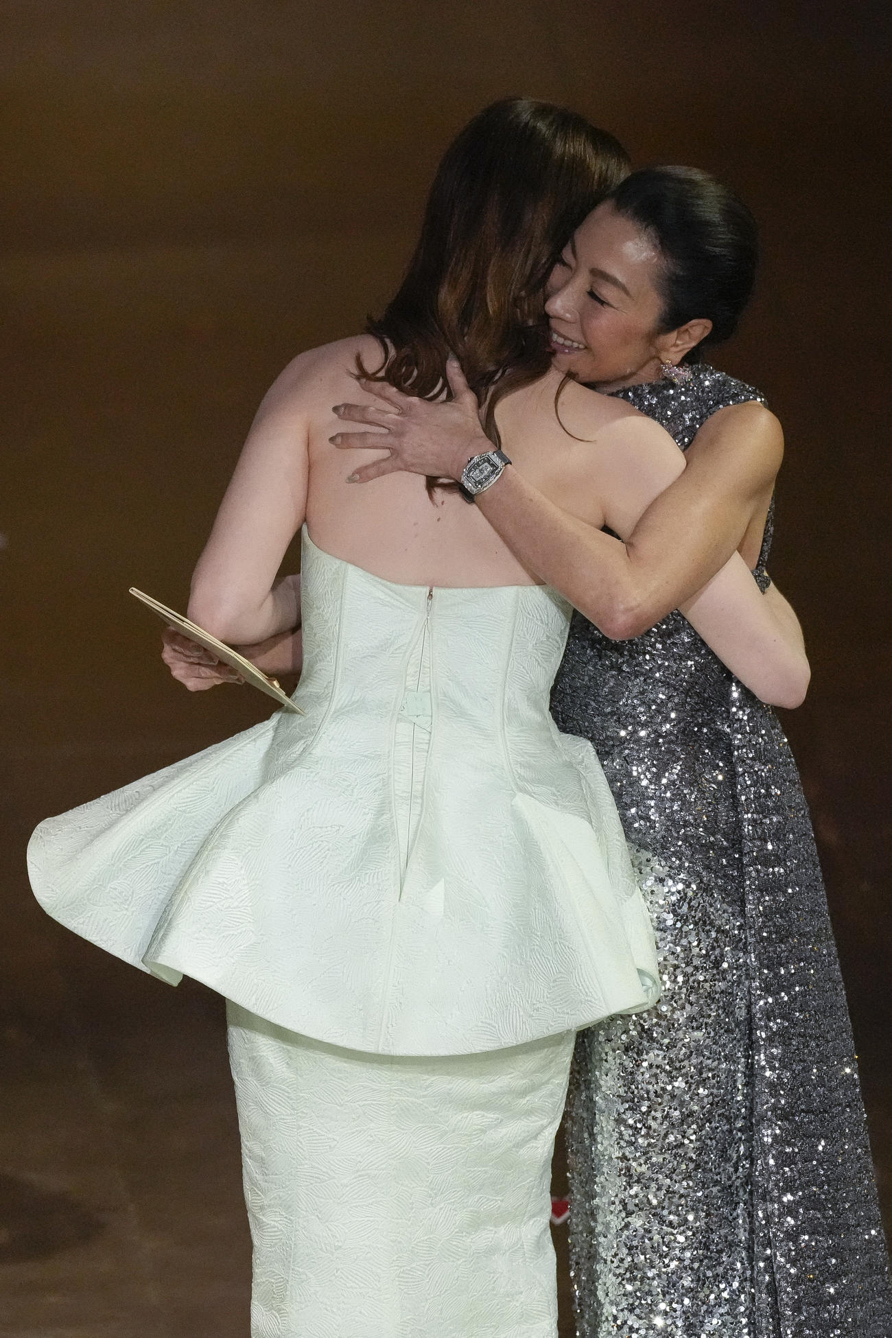 第96回アカデミー賞授賞式で、主演女優賞を受賞したエマ・ストーン（左）はドレスのファスナーが壊れてしまう。右はミシェル・ヨー（AP）