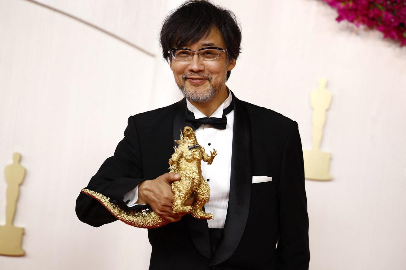 ゴジラのフィギュアを手にレッドカーペットを歩いた山崎貴監督（ロイター）