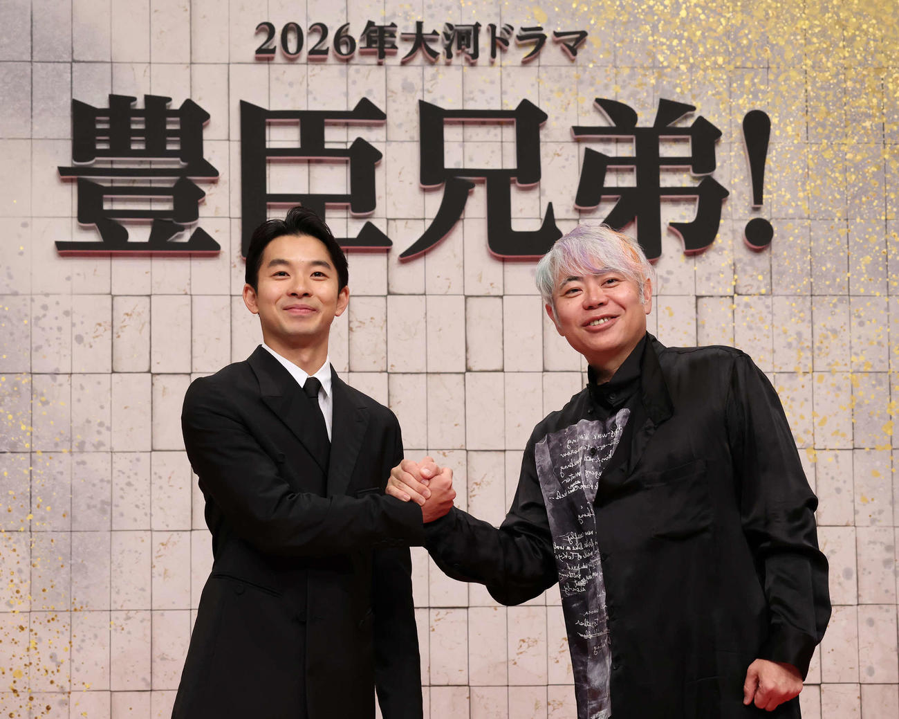 豊臣秀吉の弟秀長を演じる主演の仲野太賀（左）と握手する脚本を担当する八津弘幸（撮影・丹羽敏通）