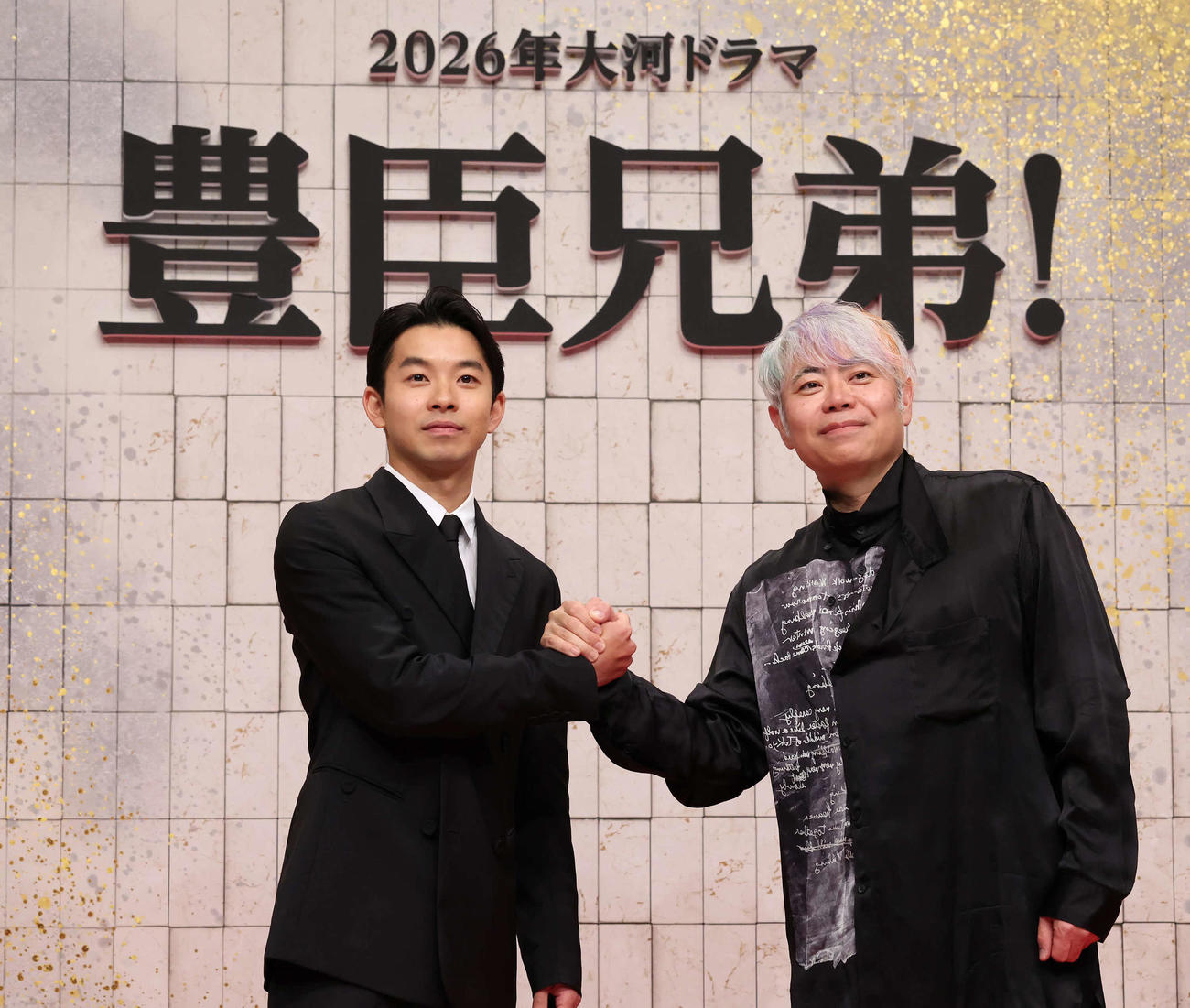 豊臣秀吉の弟秀長を演じる主演の仲野太賀（左）と握手する脚本を担当する八津弘幸（撮影・丹羽敏通）