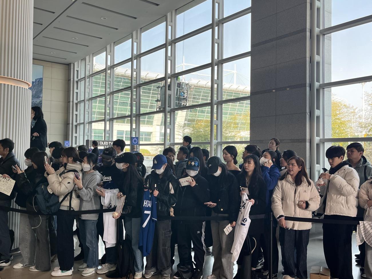 仁川国際空港で韓国・ソウル入りする大谷翔平投手らドジャースを待つファンと報道陣。窓拭きの作業員がベストポジションを確保！？（撮影・斎藤直樹）