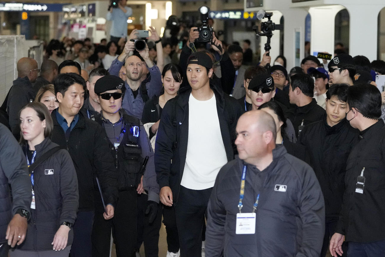 韓国・仁川空港に到着したドジャース大谷翔平投手。後方左を歩くのが新妻（AP）