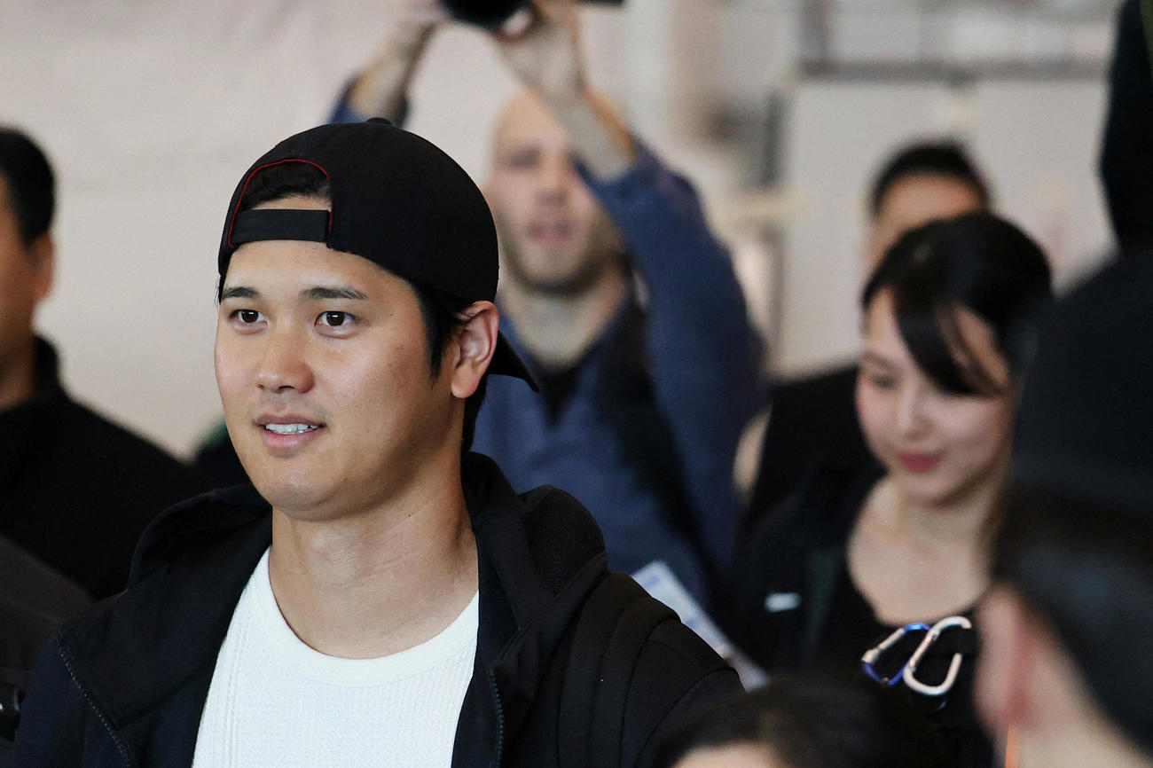 韓国・仁川空港に到着したドジャース大谷翔平投手。その後を新妻（右）が続く（ロイター）