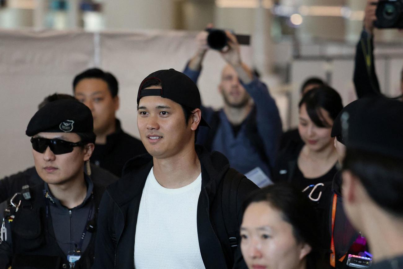 韓国・仁川空港に到着したドジャース大谷翔平投手と後ろに続く新妻（ロイター）