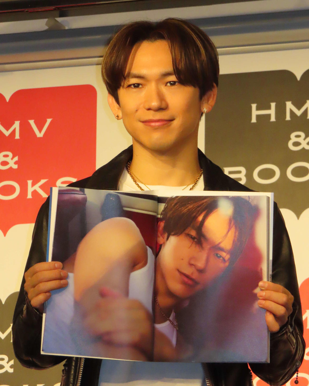 初写真集の発売イベントで、お気に入りページを見せるEXILE NAOTO