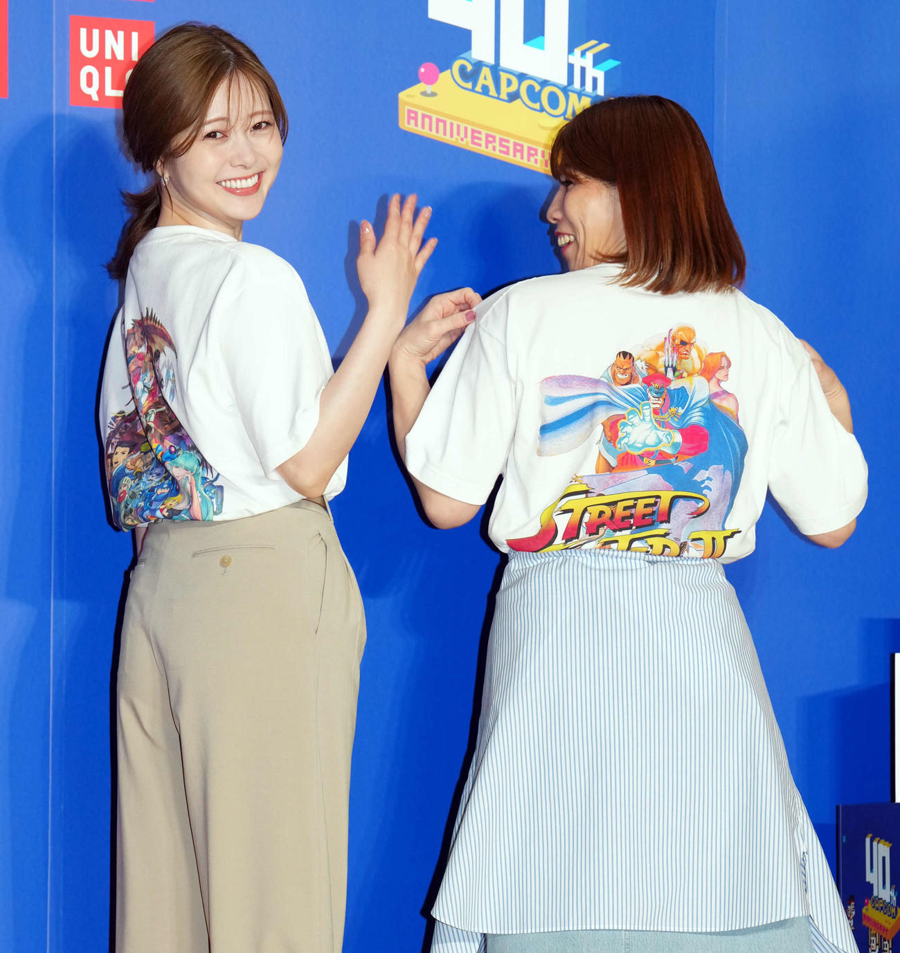 特別なUTコレクションのバックプリントを見せながら吉田沙保里さん（右）とともに笑顔を見せる白石麻衣（撮影・たえ見朱実）