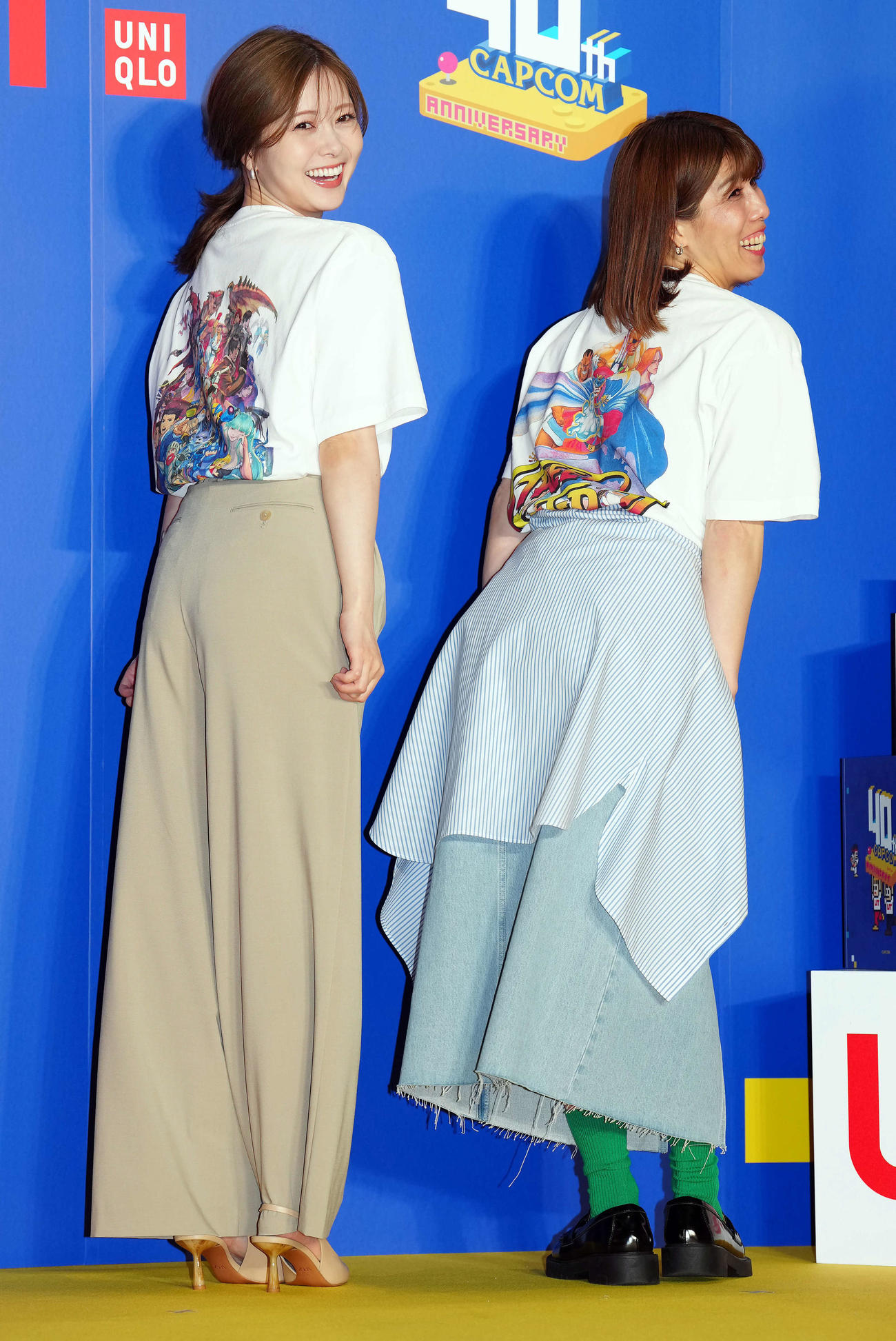 特別なUTコレクションのバックプリントを見せながら吉田沙保里さん（右）とともに笑顔を見せる白石麻衣（撮影・たえ見朱実）