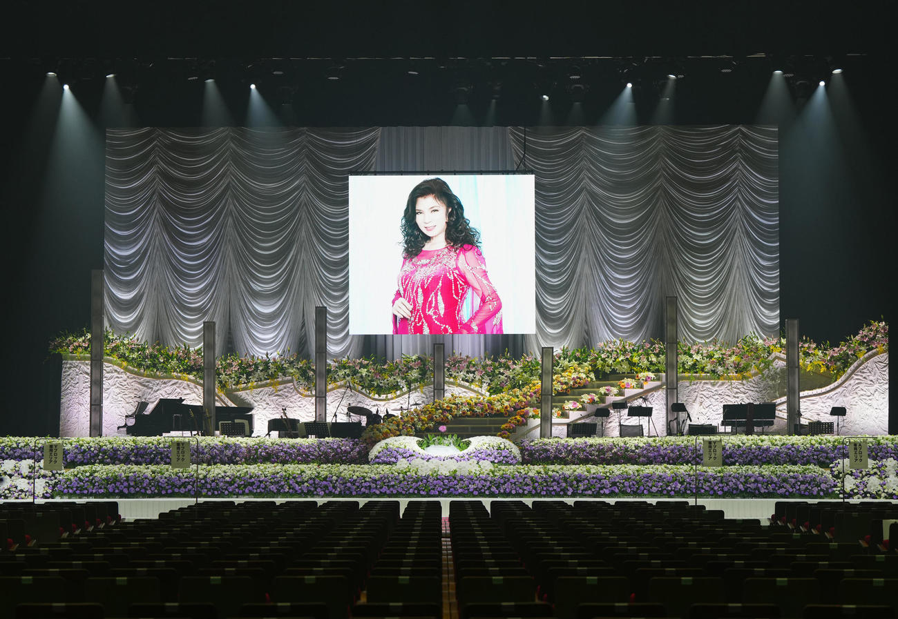 八代亜紀さんがコンサートで使用していた美術セットにコチョウラン、バラ、紫のカーネーションで装飾された祭壇（撮影・江口和貴）