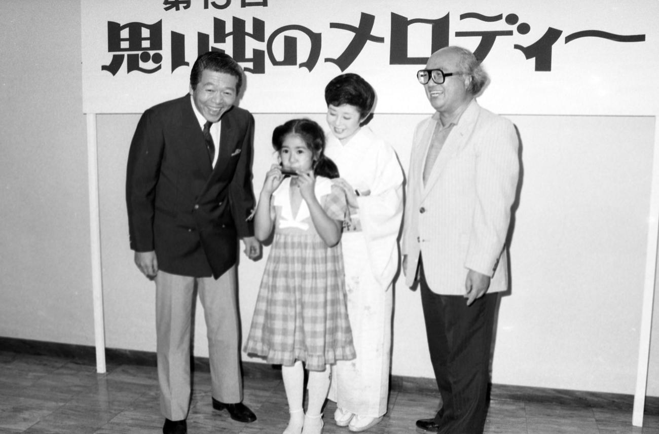NHK「第15回思い出のメロディー」のスペシャルゲストとして出演が決まった「おしん」の子役小林綾子（10歳）と鈴木健二アナ（右端）、左端は司会の相川浩アナ、右から2人目は同じく司会の森光子（1983年7月18日）