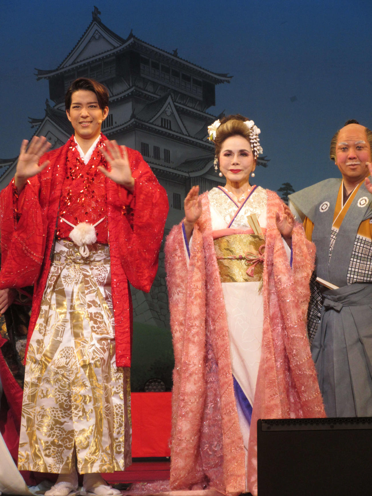 観客に手を振る花園直道（左）とデヴィ夫人（中央）。右は竜小太郎（18日、東京・明治座）