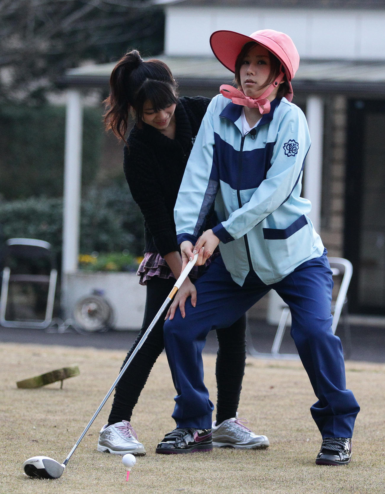AKB48山内鈴蘭（左）のアドバイスを受けながら人生初のゴルフに挑戦する大家志津香＝2011年12月12日