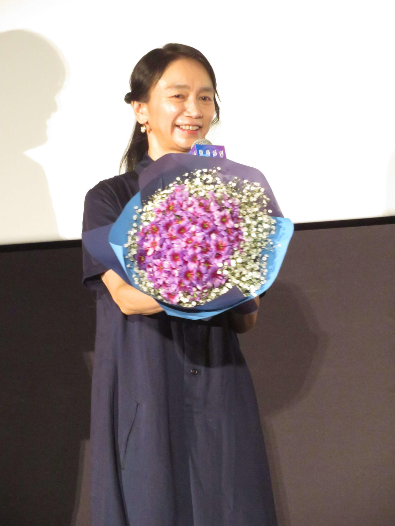 夫の山崎貴監督から贈られた花束を披露する佐藤嗣麻子監督
