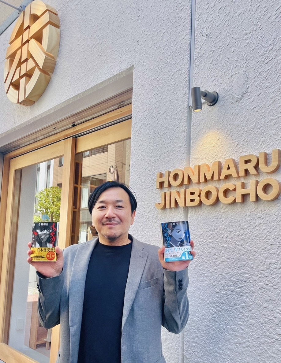 27日にオープンするシェア型書店「ほんまる」の前で「イクサガミ」を手にする今村翔吾氏