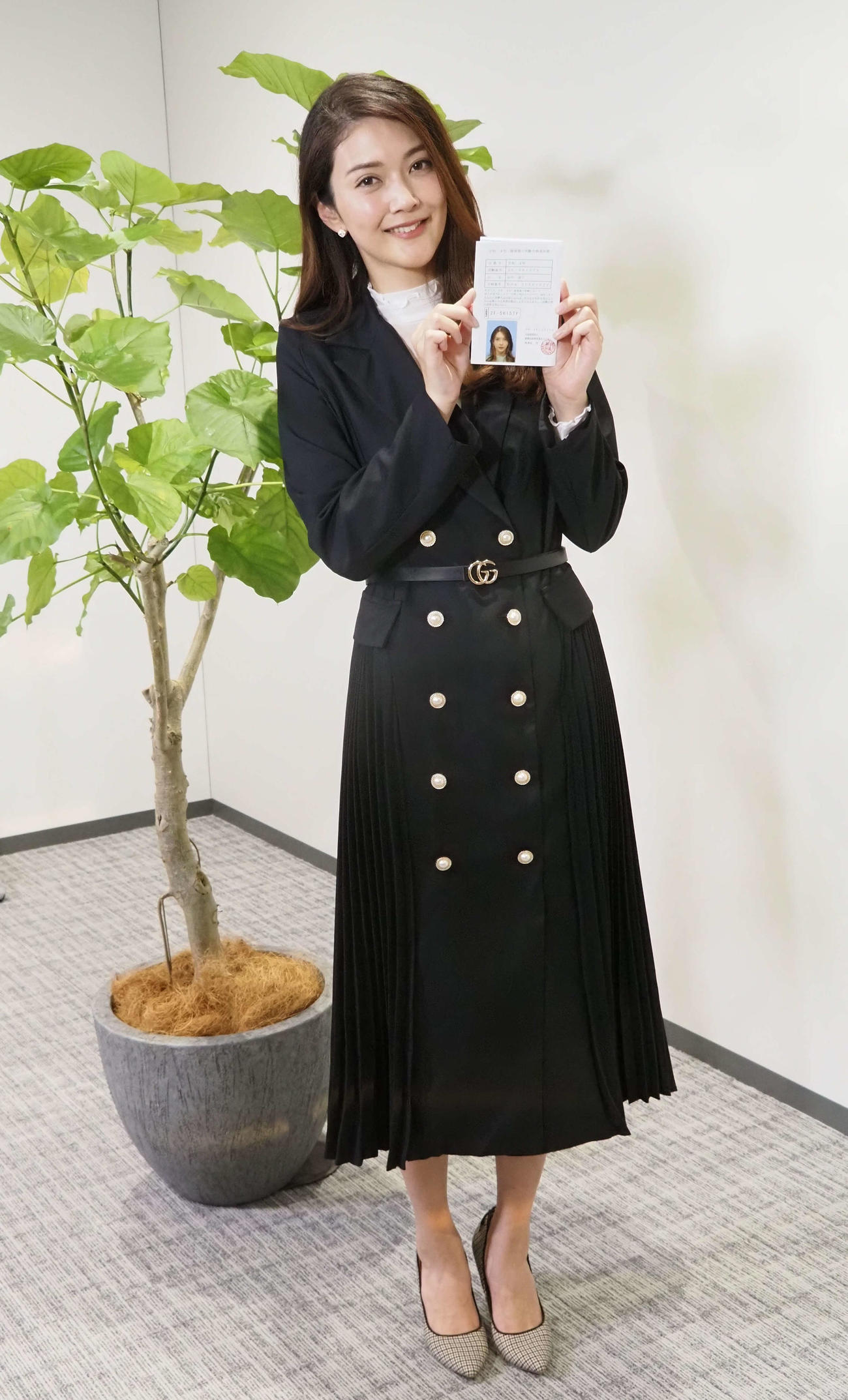 1級建築士合格通知書を手に笑顔を見せる田中道子（2022年1月撮影）