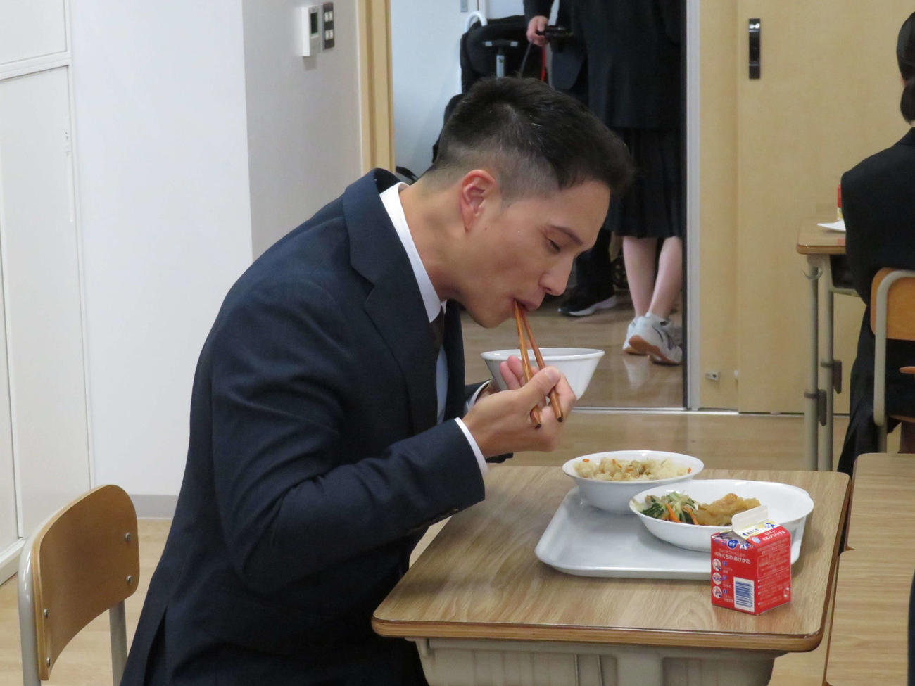 映画「おいしい給食　Road to　イカメシ」のイベントで中学校の給食の時間にサプライズ登場し、給食を食べる市原隼人