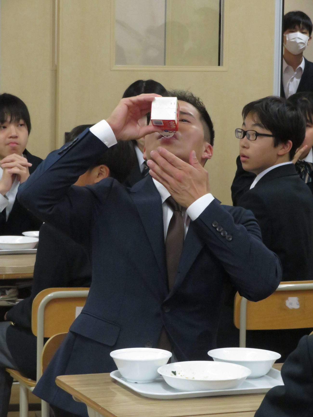 映画「おいしい給食　Road to　イカメシ」のイベントで中学校の給食の時間にサプライズ登場し、牛乳を飲む市原隼人