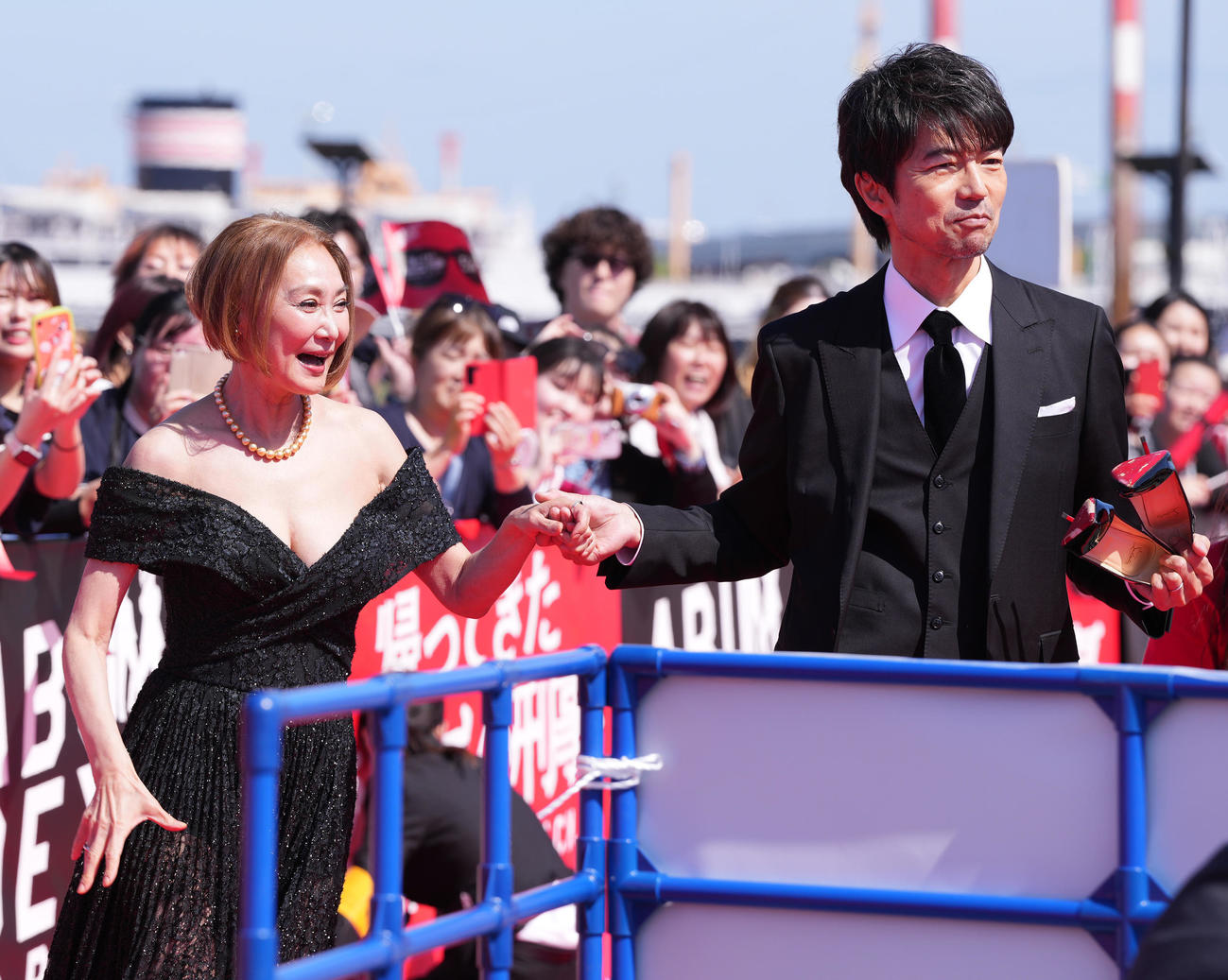 「帰ってきた　あぶない刑事」レッドカーペットイベントで浅野温子（左）の脱いだヒールを持ってあげる仲村トオル（撮影・鈴木みどり）