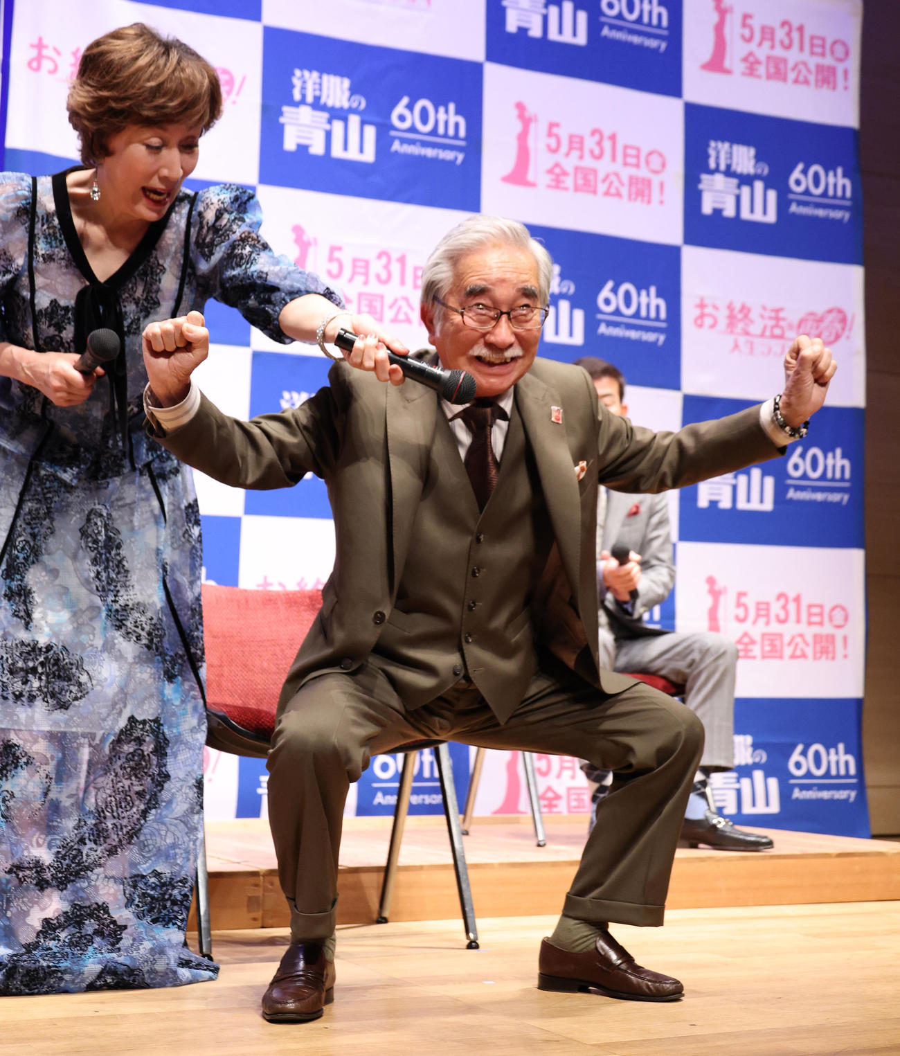 映画「お終活　再春！人生ラプソディ」舞台あいさつでスクワットを披露する大村崑。左は高畑淳子（撮影・中島郁夫）