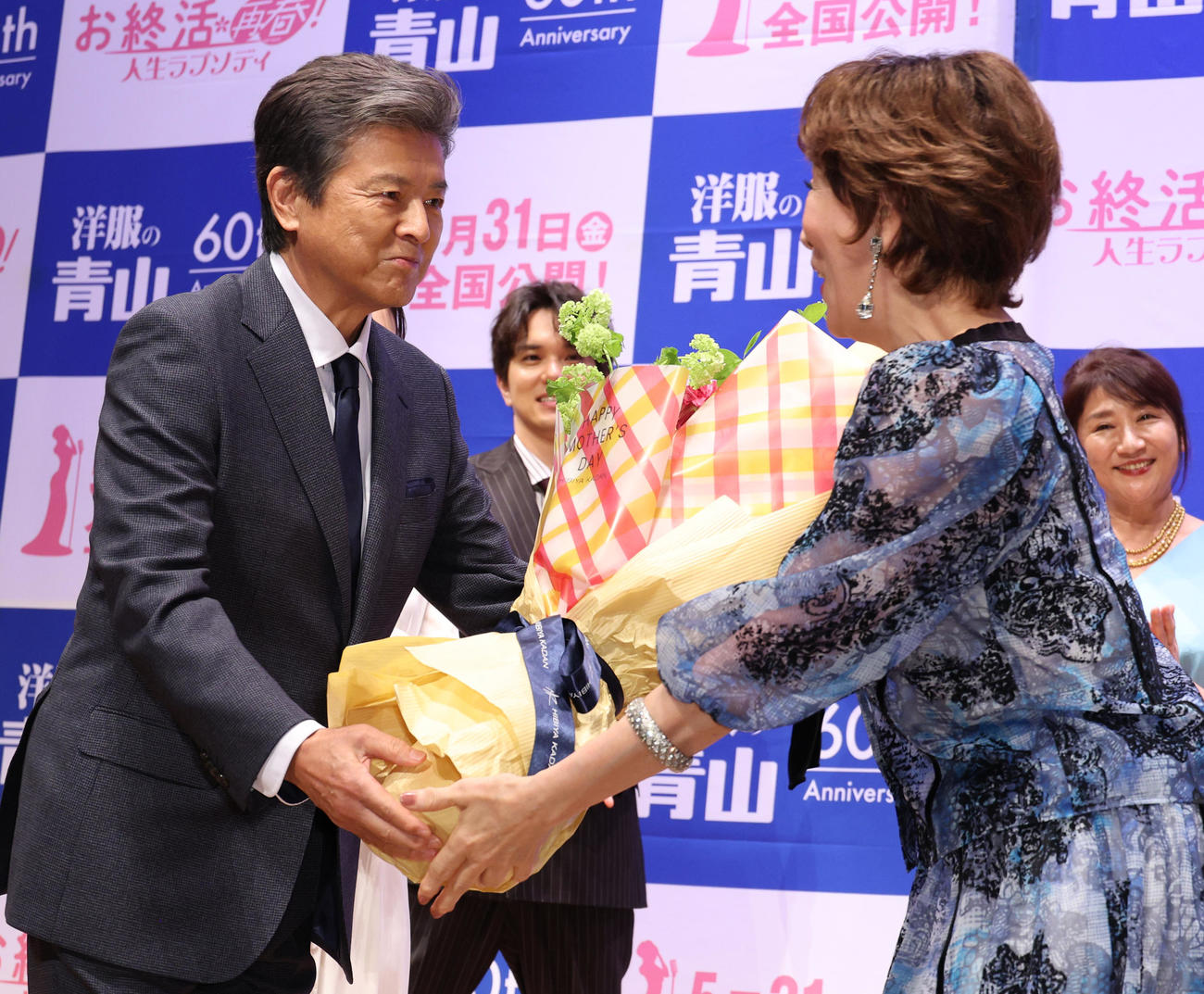 映画「お終活　再春！人生ラプソディ」舞台あいさつで三浦友和（左）から花束を贈られる高畑淳子（撮影・中島郁夫）