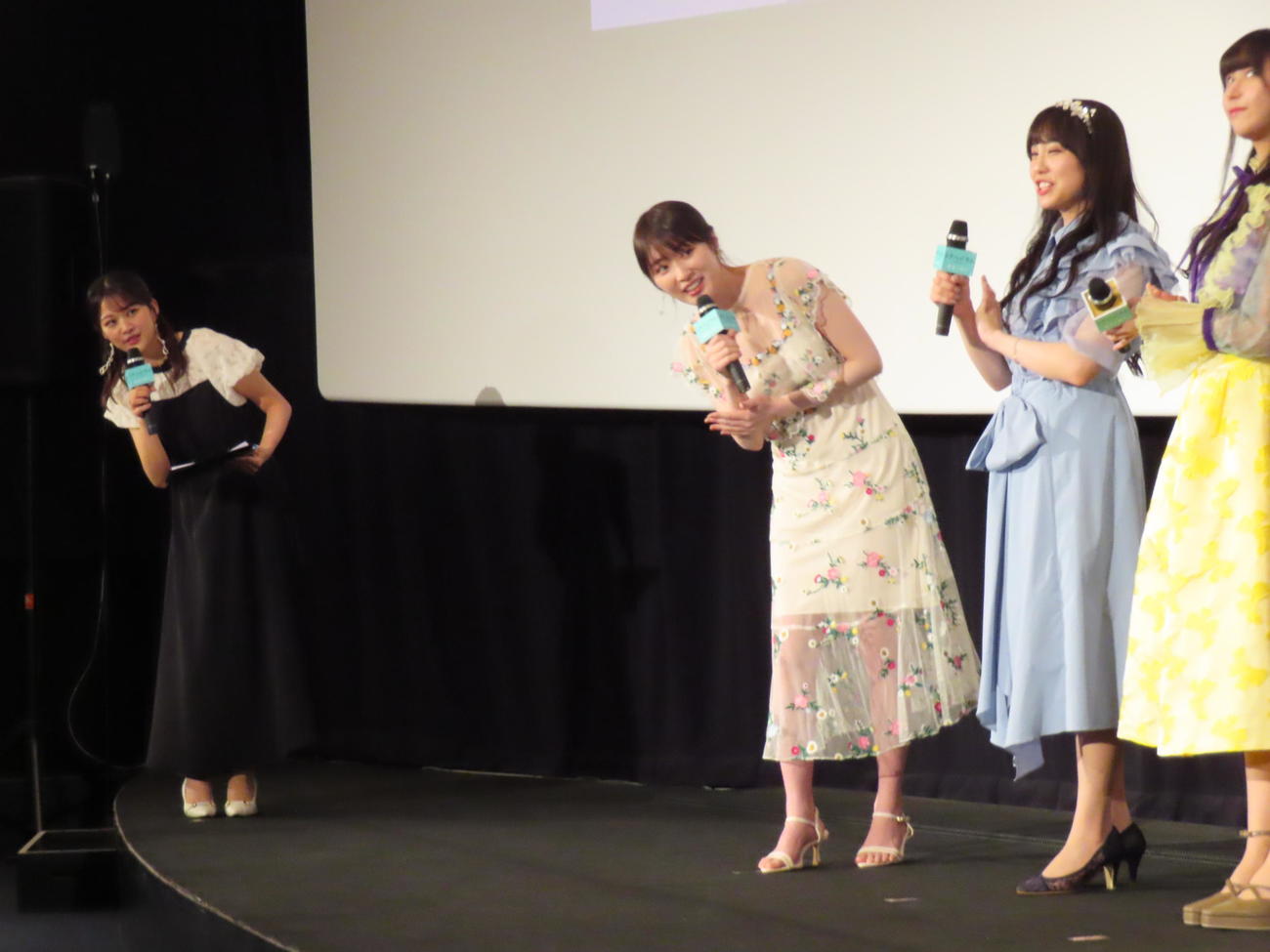アニメ映画「トラペジウム」の公開記念舞台あいさつで司会を務めた原田葵アナウンサー（左）が、高山一実（左から2人目）とともに出席者の顔をのぞき込む