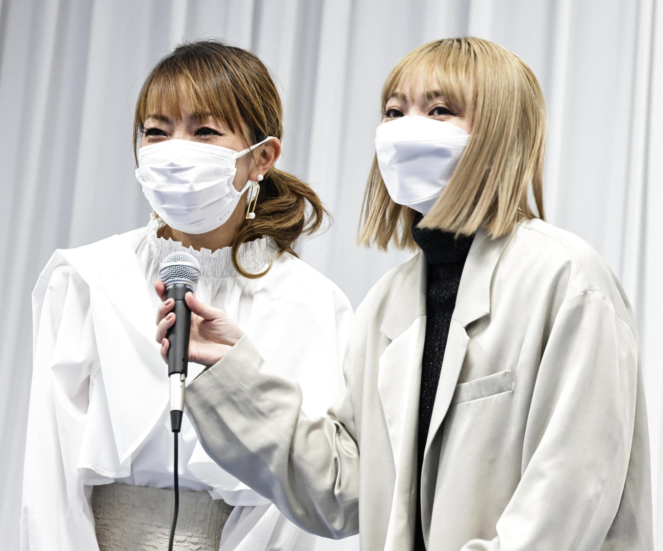 22年2月、コロナワクチン接種を呼びかけるイベントであいさつするMAXのREINA（左）とMINA