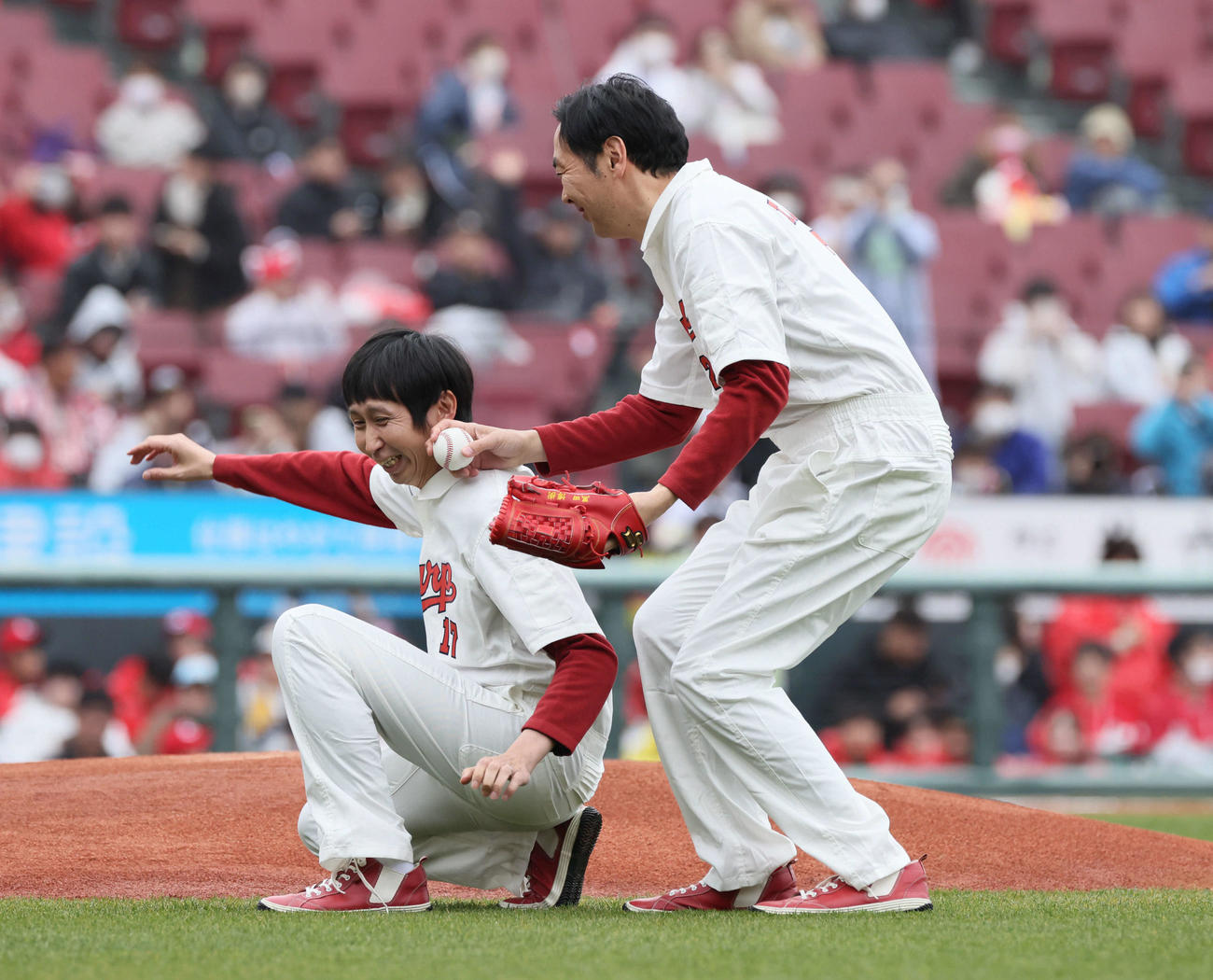 2024年3月24日、広島対ソフトバンク　始球式に向かう途中、ずっこけるアンガールズの山根良顕（左）と田中卓志