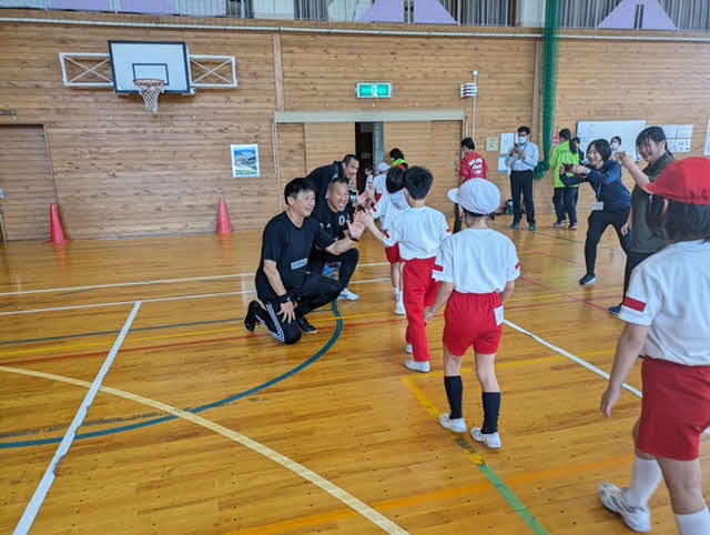 輪島市立町野小学校でサッカーの指導を行う武田修宏氏（中央手前）