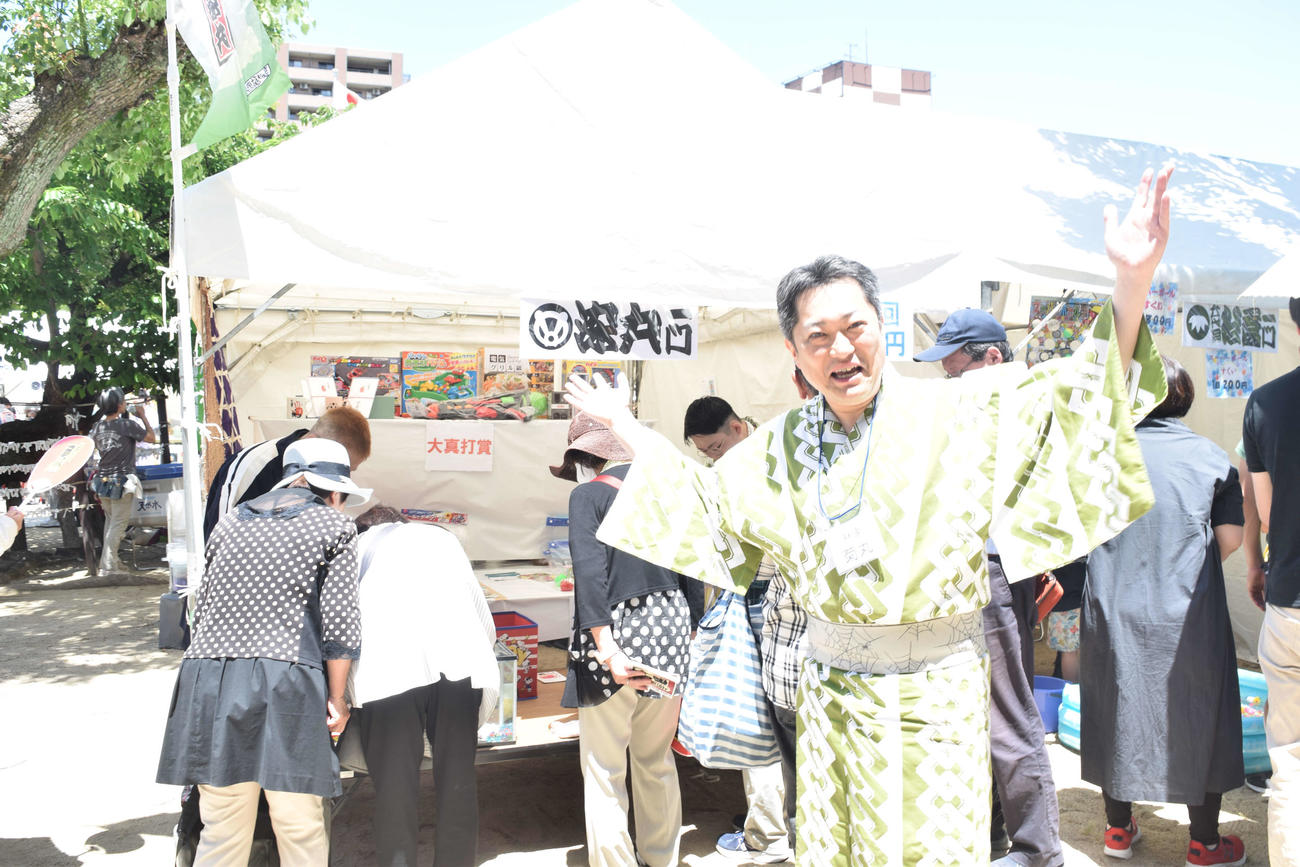 彦八まつりで一門の出店に立つ林家菊丸（撮影・阪口孝志）