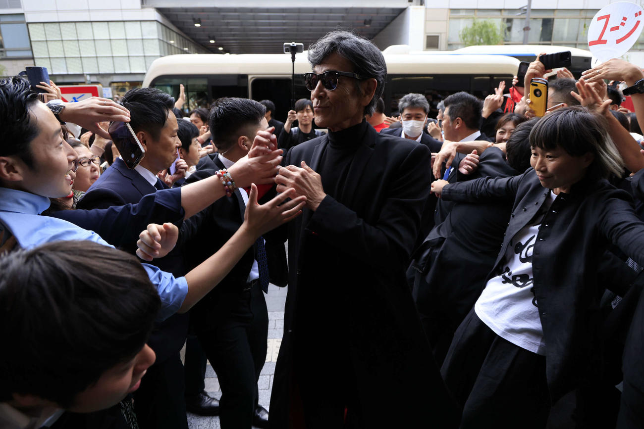 映画「帰ってきた　あぶない刑事」の初日舞台あいさつのため、ファンに迎えられて劇場入りする柴田恭兵