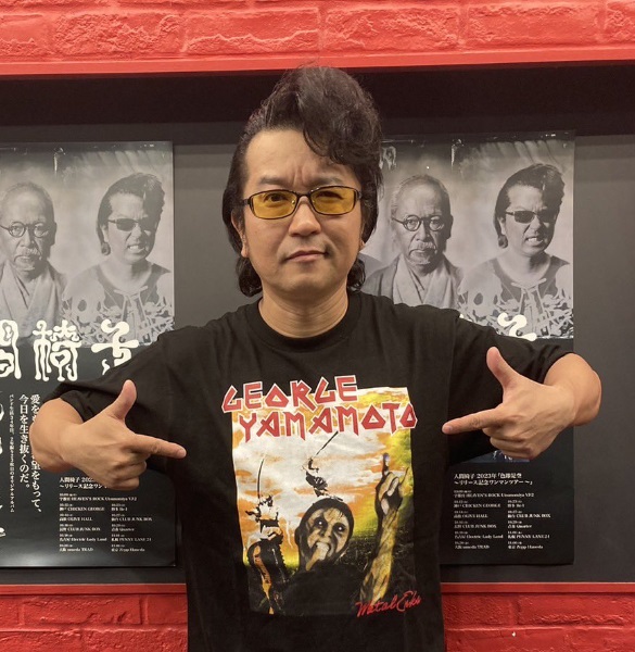 山本譲二のゾンビTシャツを着てメロイックサインを決めるナカジマノブ（人間椅子）
