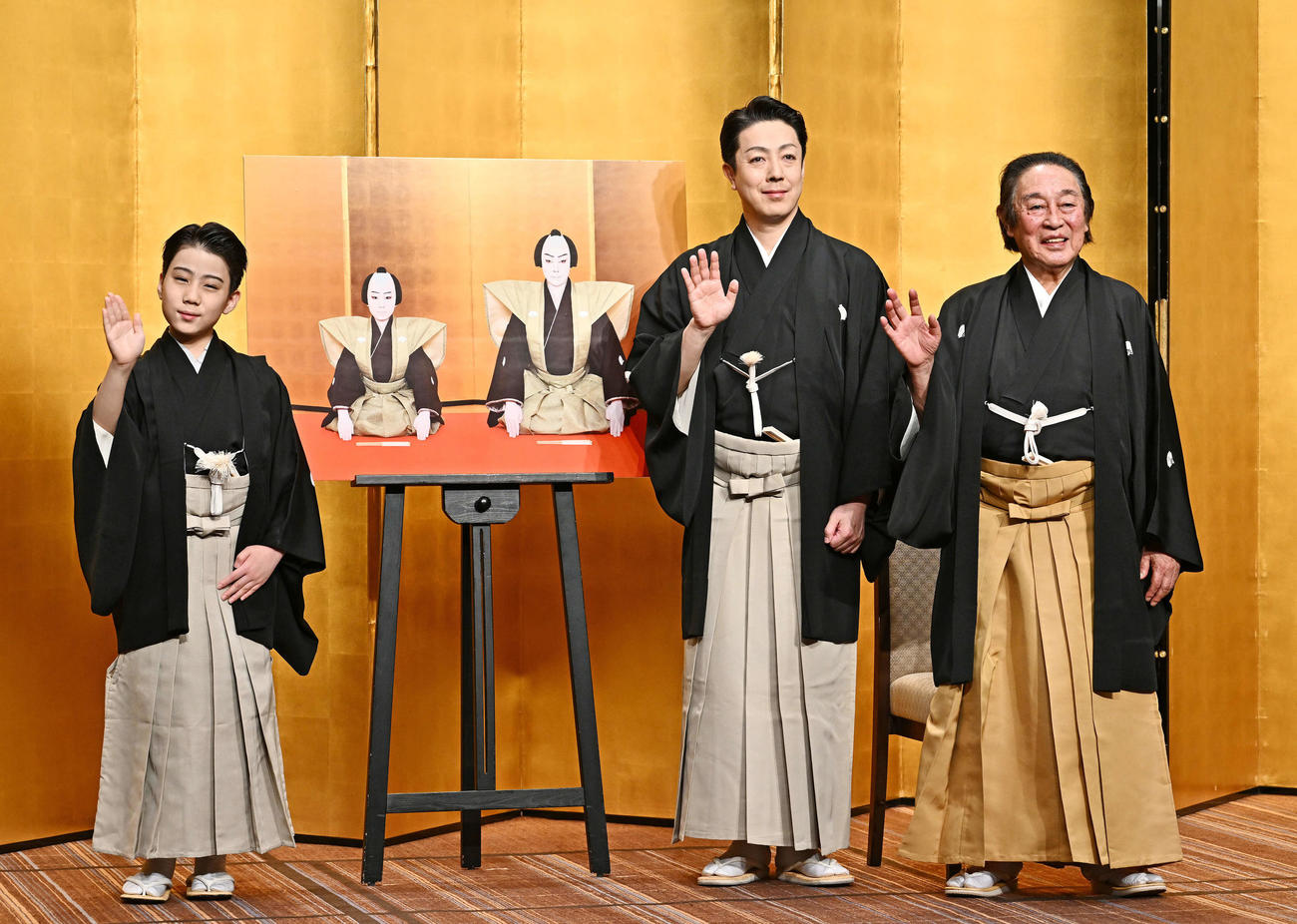 襲名披露会見でカメラに手を振る尾上丑之助（左）、尾上菊之助（中央）、尾上菊五郎（撮影・滝沢徹郎）