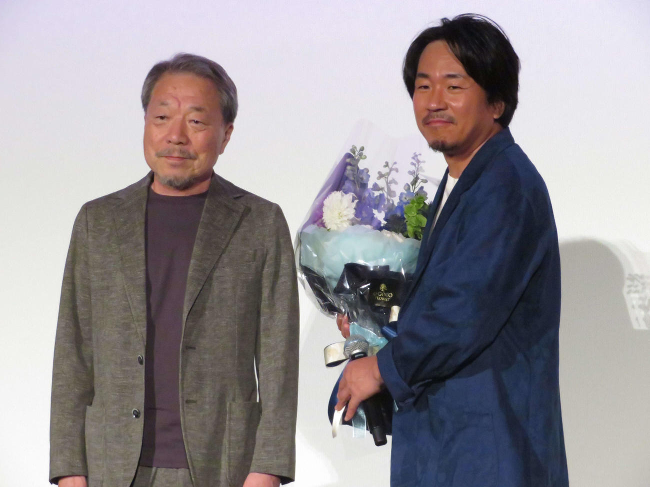 映画「告白　コンフェッション」初日舞台あいさつに登壇し、かわぐちかいじ氏から花束を受け取ったヤン・イクチュン