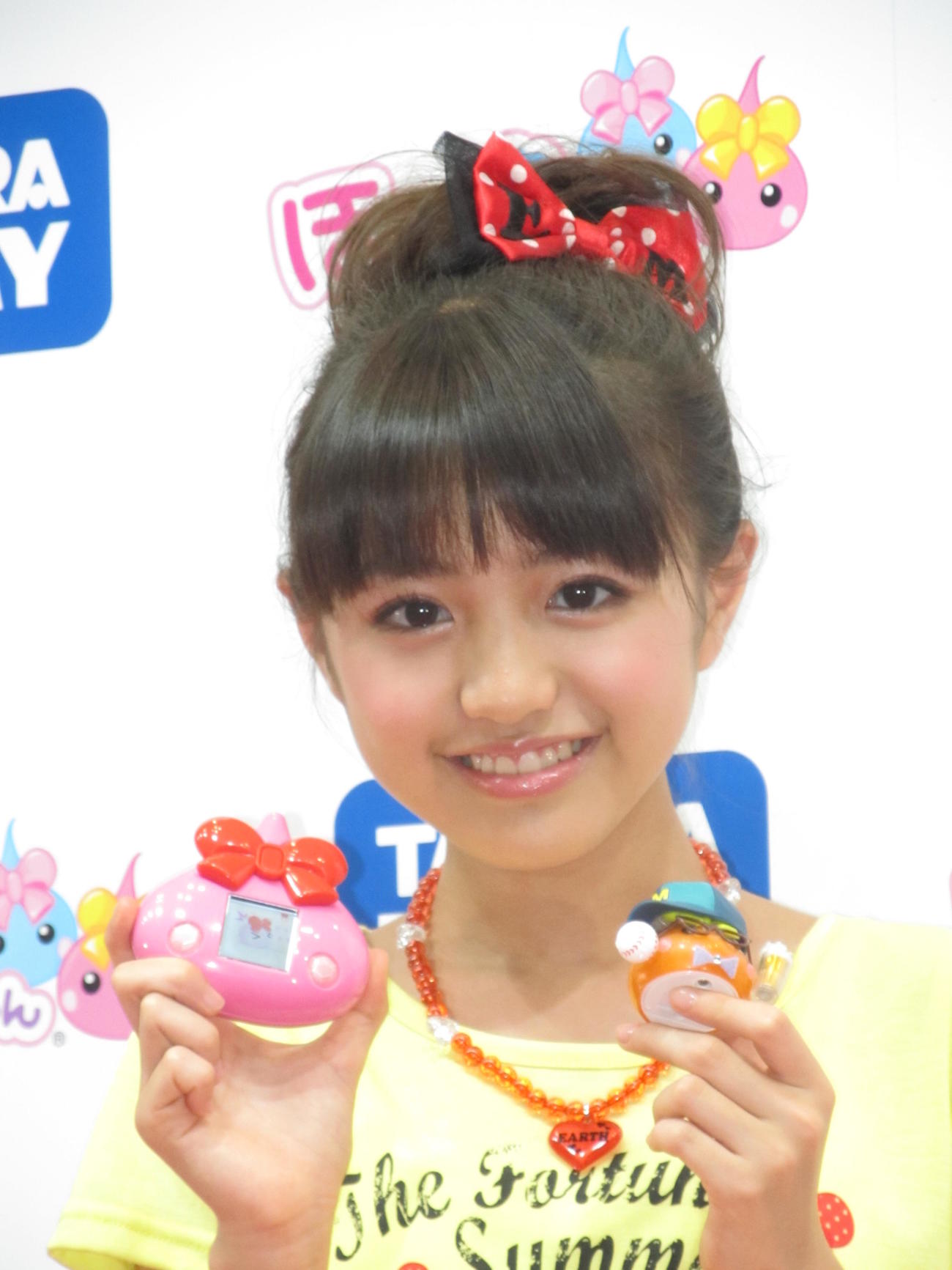 父親の野々村真をイメージしたほっぺちゃん人形（右下）を持って笑顔を見せる香音（2013年6月撮影）