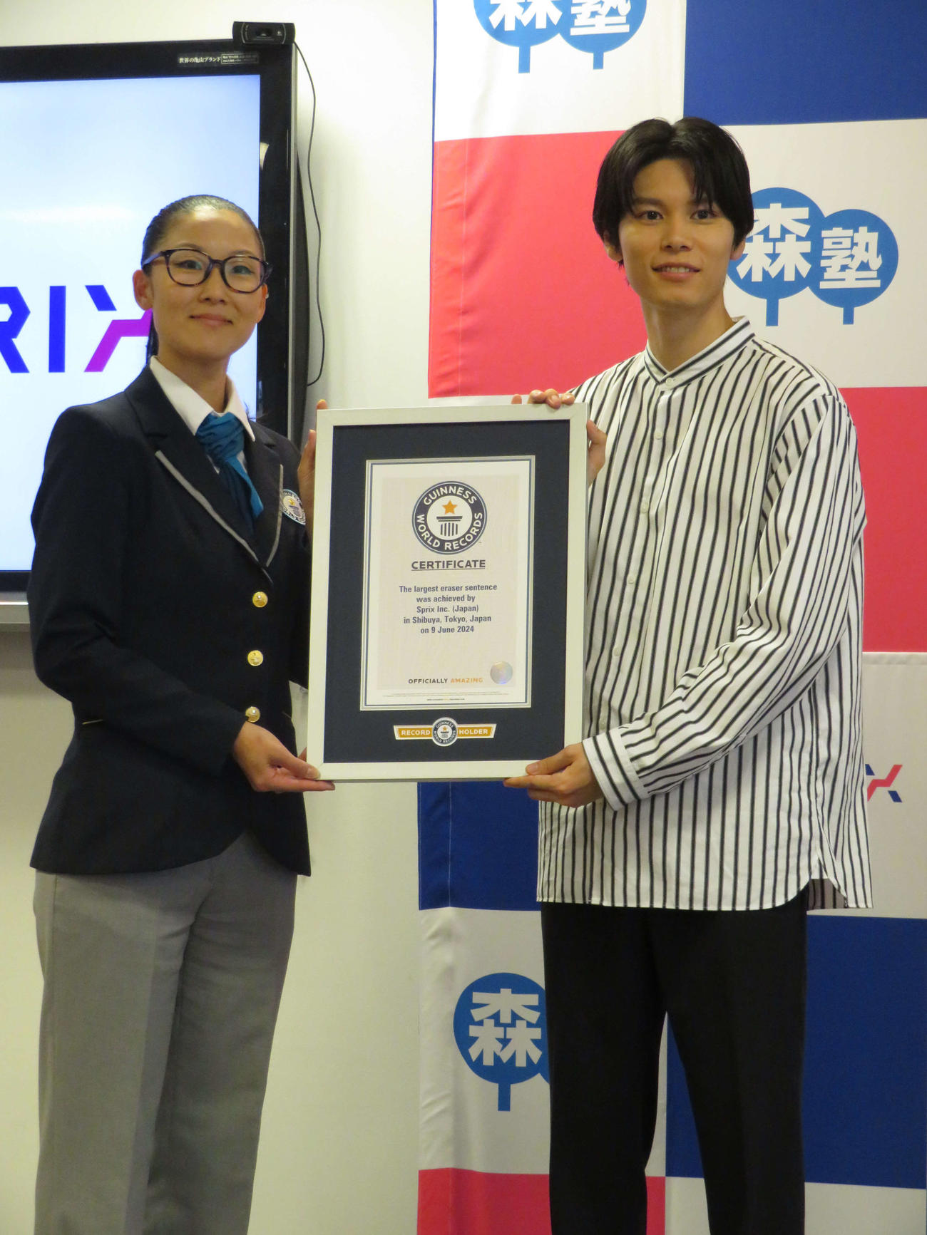 「消しゴムでギネス世界記録〓（商標記号）に挑戦！～これからの未来を担う子どもたちへ贈る巨大消しゴムエール～」でギネス認定書を受け取る萩原利久