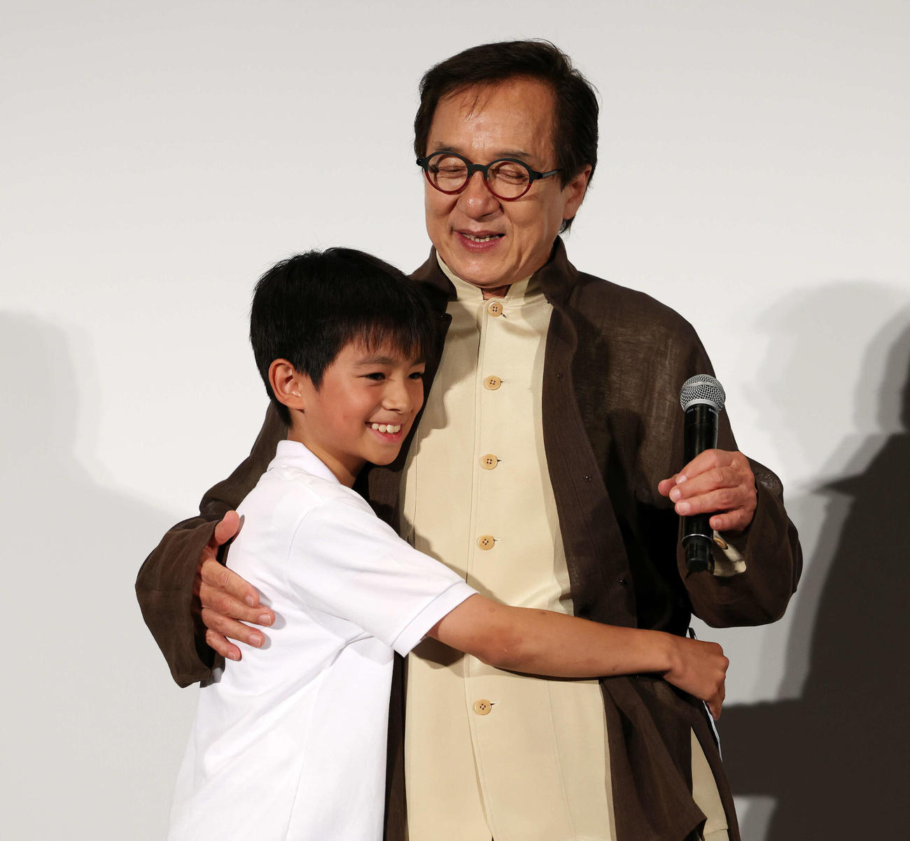 おかえり、ありがとう、ジャッキー！映画「ライド・オン」集大成舞台あいさつで宣伝アドバイザー・山田くん（左）とハグするジャッキー・チェン（撮影・宮地輝）