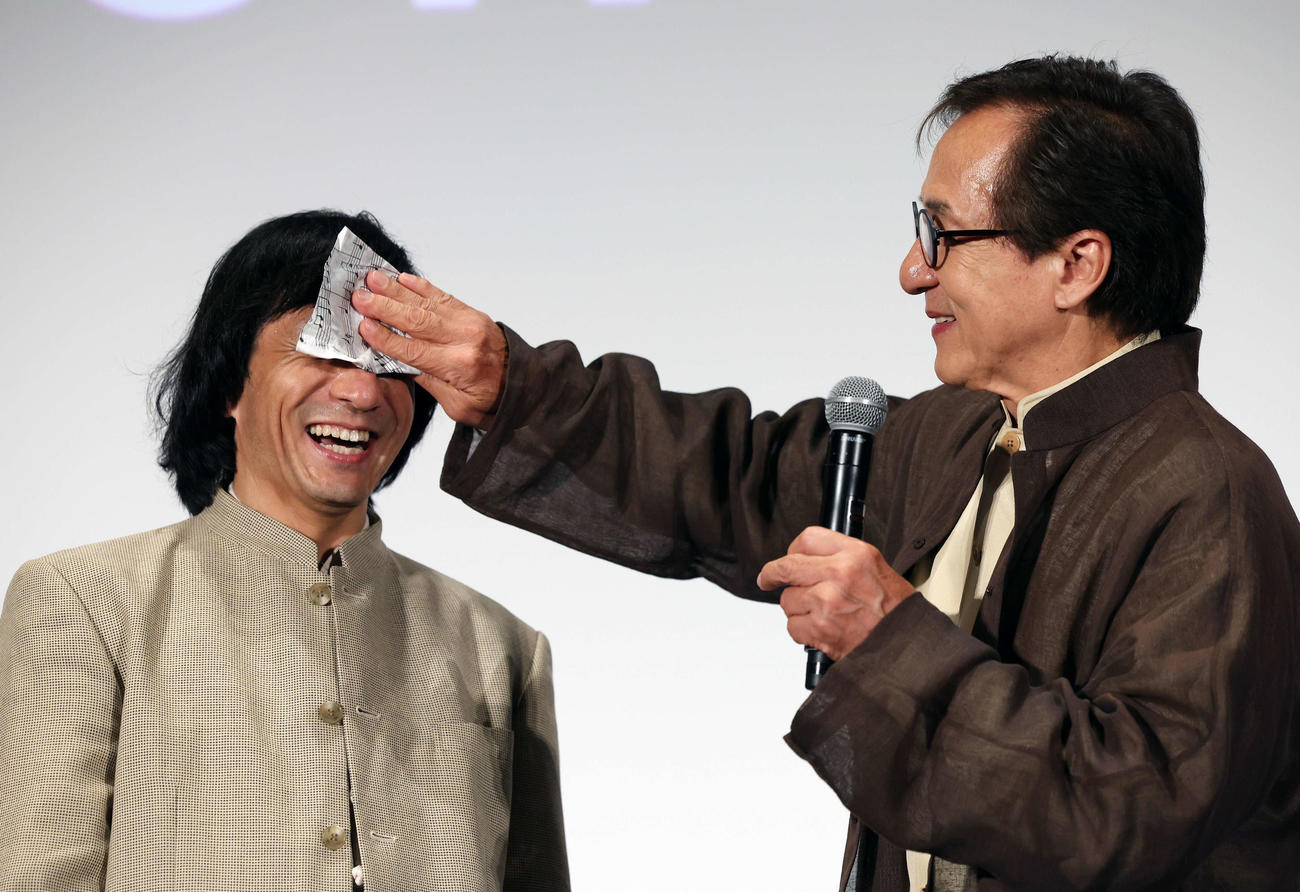 おかえり、ありがとう、ジャッキー！映画「ライド・オン」集大成舞台あいさつでジャッキーちゃん（左）の汗を拭くジャッキー・チェン（撮影・宮地輝）