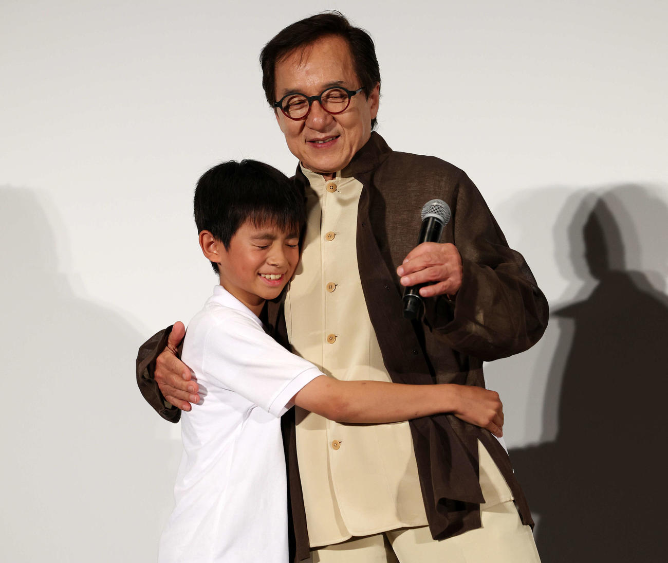 おかえり、ありがとう、ジャッキー！映画「ライド・オン」集大成舞台あいさつで宣伝アドバイザー・山田くん（左）とハグするジャッキー・チェン（撮影・宮地輝）