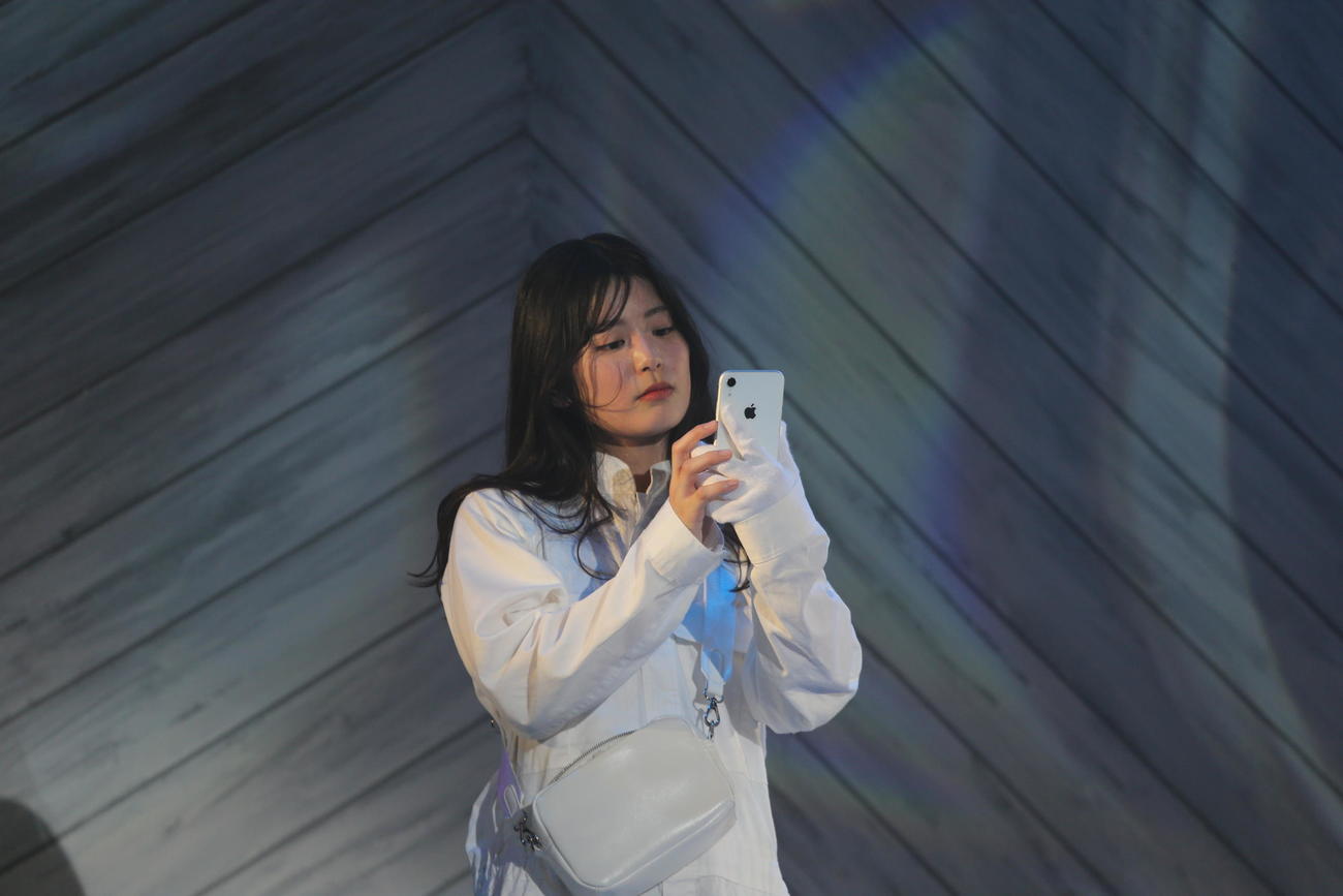 元ファイターズガールの滝谷美夢が、スマホを見つめるシーン（撮影・中島洋尚）