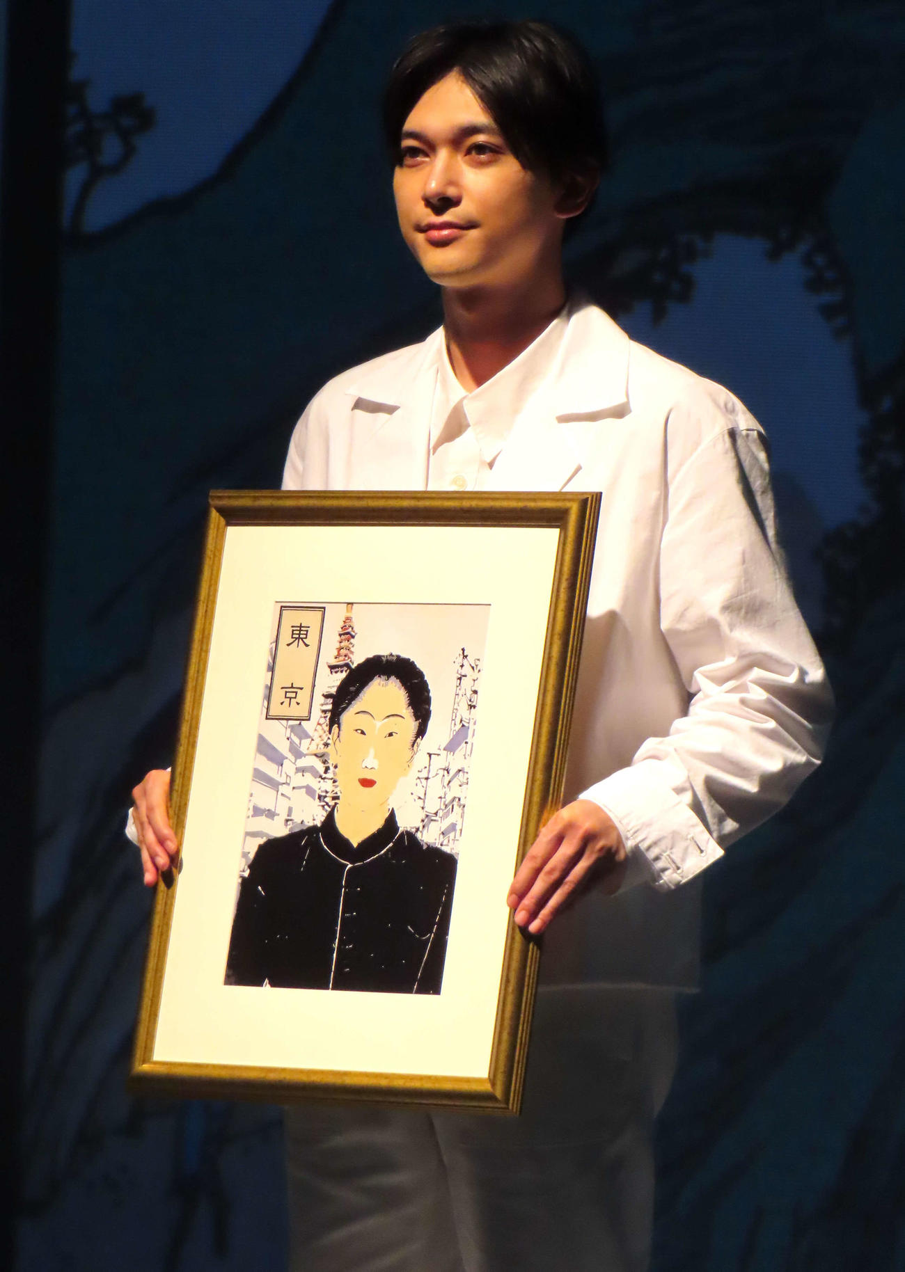 「AI北斎」が描いた自身の似顔絵を手に写真に納まる吉沢亮