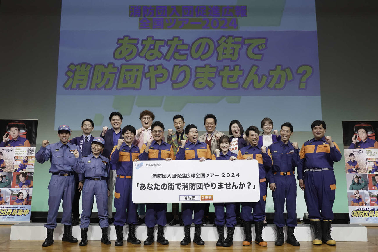 消防団入団促進広報全国ツアー「あなたの街で消防団やりませんか？」発表イベントに出席した、前列左から小池基、宮本由美子、銀シャリの鰻、橋本、今田耕司、森迫永依、ファミリーレストランハラダ、木下弱、ほのまる向井。後列左からタケト、マユリカ坂本、中谷、COWCOW多田健二、善し、紅しょうが熊元プロレス、稲田美紀