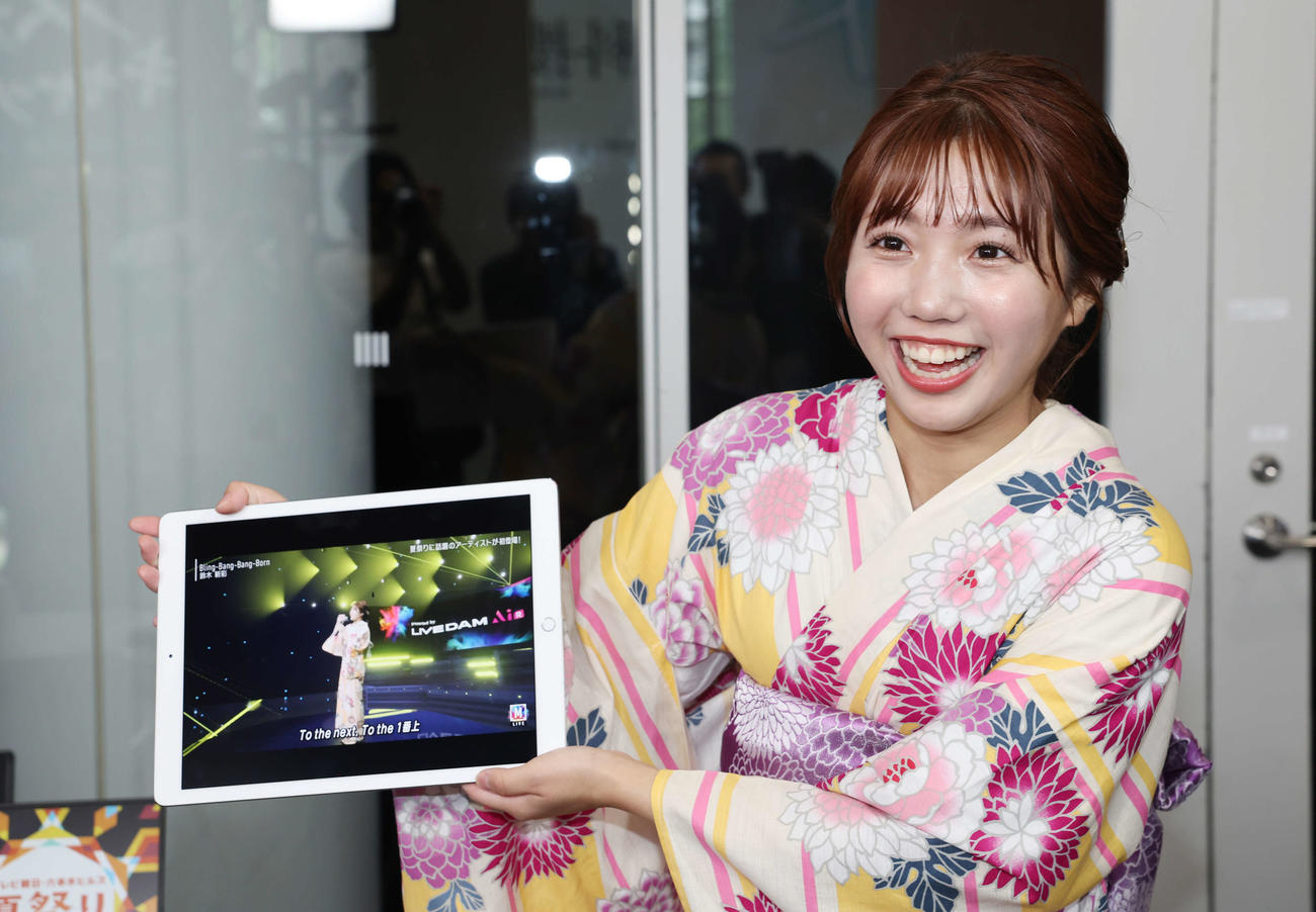 「あなたが出演！　MUSIC STATION　未来ステージ　presented by DAM AiR」ブースで撮影した映像を笑顔で見る鈴木新彩アナウンサー（撮影・宮地輝）