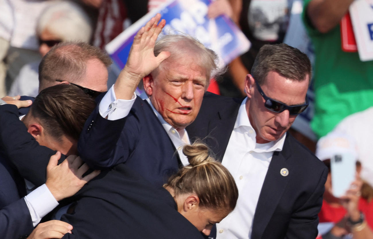 米ペンシルベニア州バトラーの選挙集会で銃声が鳴り響き、大統領警護隊員に警護されるトランプ前大統領（ロイター＝共同）
