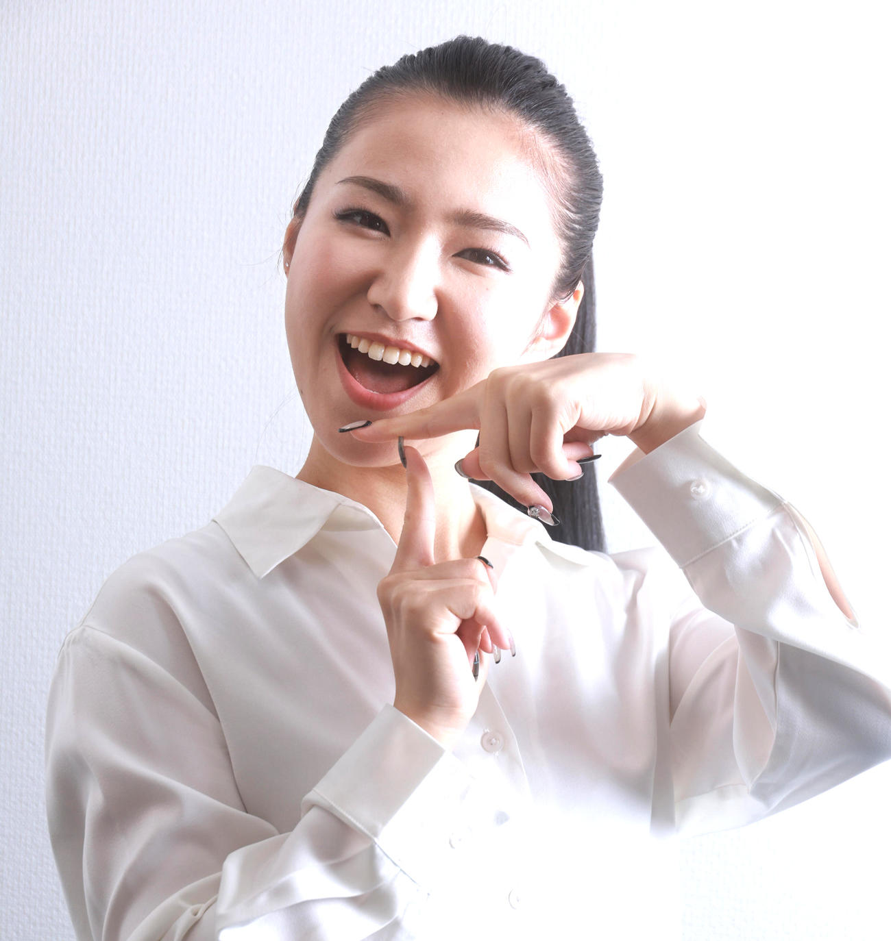 笑顔で新曲「TATSUYA」の「T」をポージングする田中あいみ（撮影・中島郁夫）