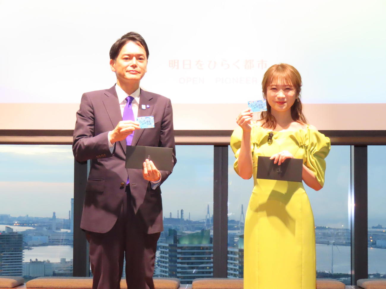 「ヨコハマ未来創造会議」本格始動を宣言し、会員証をお披露目する秋元真夏（右）。左は山中竹春横浜市長