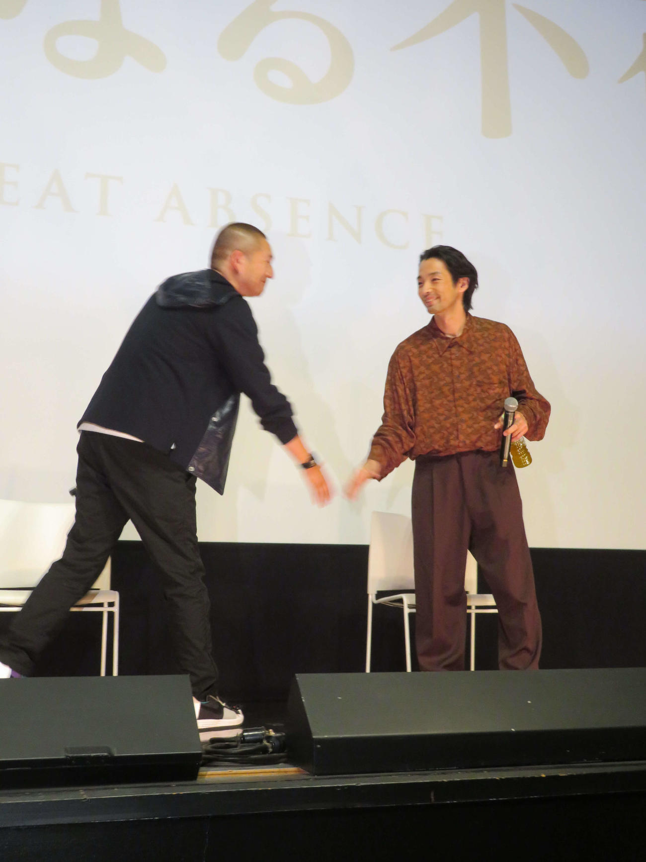 映画「大いなる不在」ティーチインイベントに登壇し、握手する森山未來（右）と近浦啓監督（撮影・村上幸将）