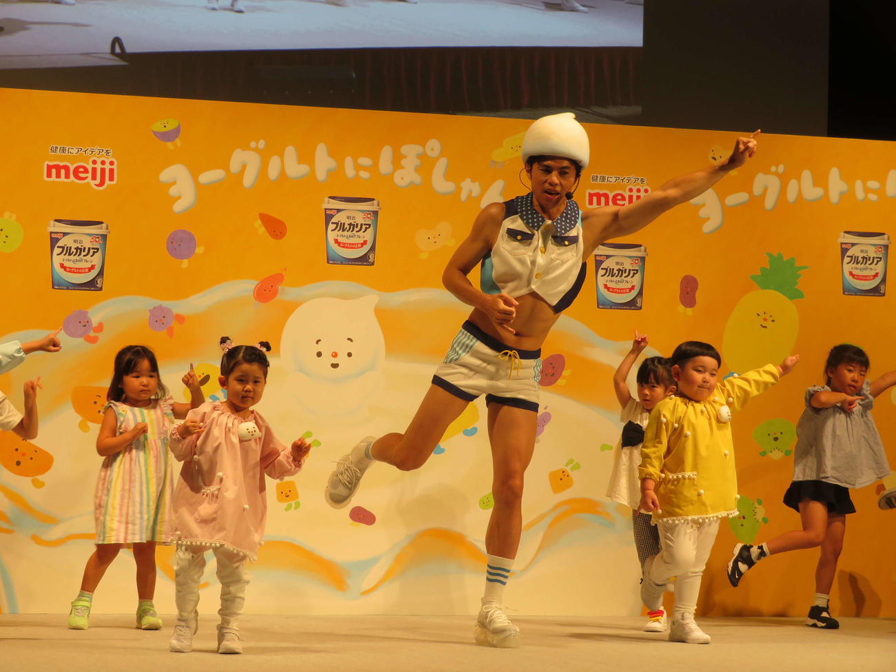 明治ブルガリアヨーグルト「ヨーグルトにぽしゃん！」お披露目会で、子どもたちと「ヨーグルトにぽしゃん！のうた」を実演する小島よしお（撮影・村上幸将）