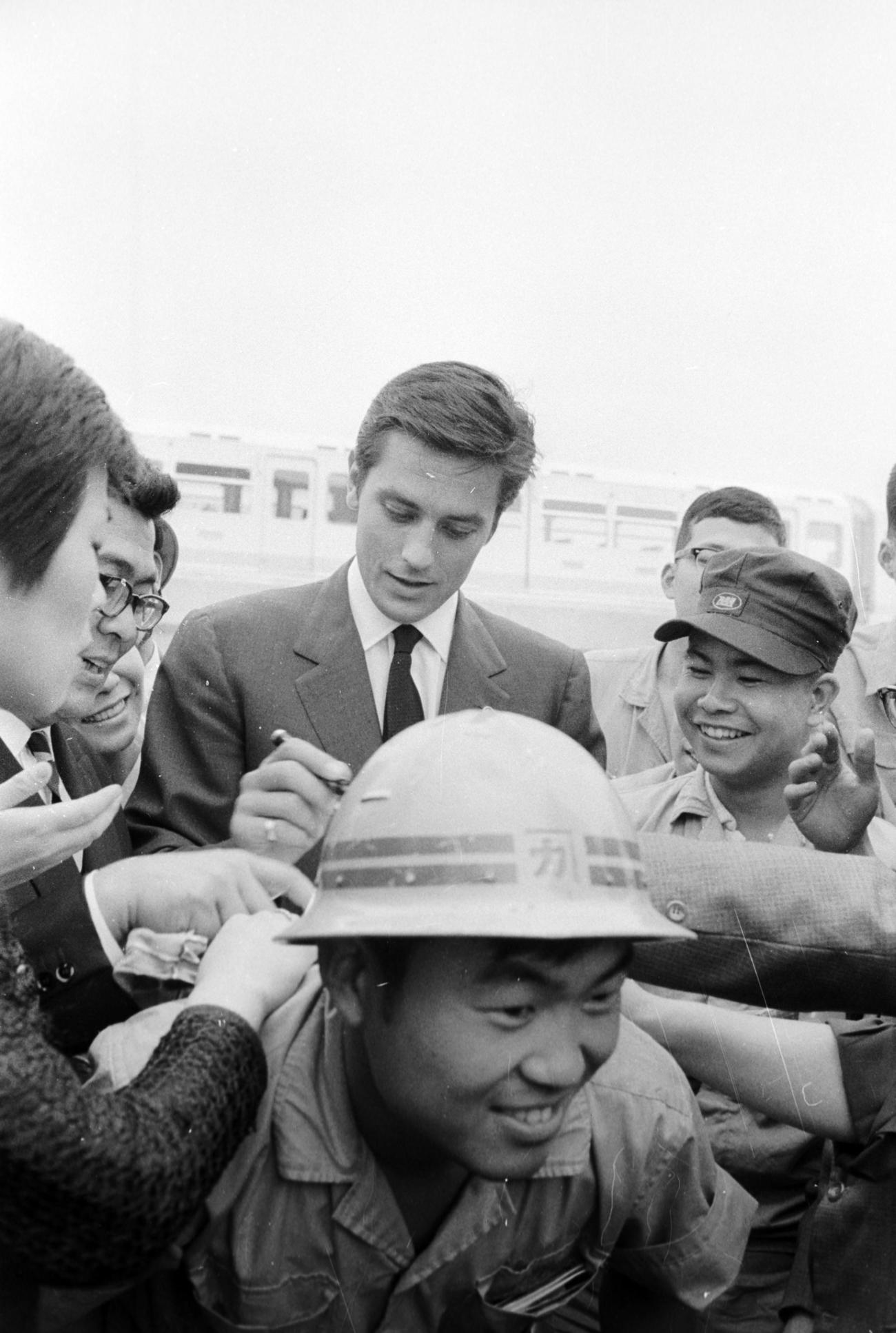 開通予定のモノレールに試乗した来日中のフランス俳優アラン・ドロンさんは、気軽にサインに応じる（1964年6月撮影）